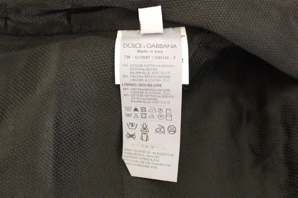 Étiquette d’entretien blanche dolce & gabbana avec texte et symboles noirs sur tissu texturé noir d’un gilet robe coton blend