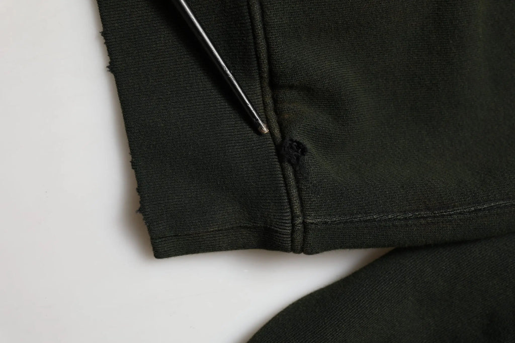 Détail du tissu noir en coton avec petite déchirure près de la couture sur le sweatshirt dolce & gabbana homme