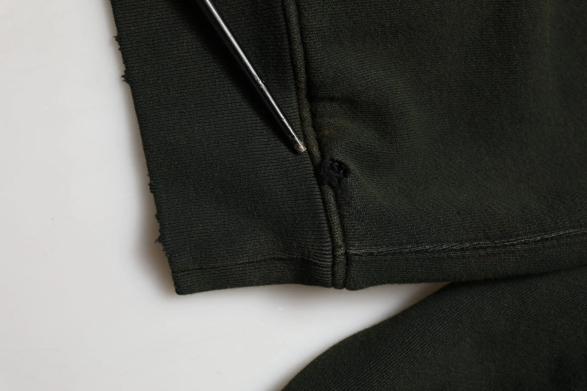 Détail du tissu noir en coton avec petite déchirure près de la couture sur le sweatshirt dolce & gabbana homme