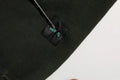 Étiquette noire avec lettrage bleu sarcelle cousue sur un pull homme noir en coton dolce & gabbana col rond