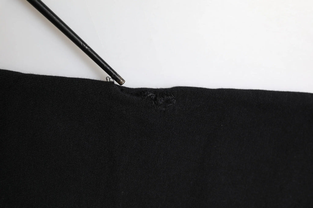 Dolce & gabbana black cotton crown jogger sweatpants with a small tear near the top edge pointed by a black pencil