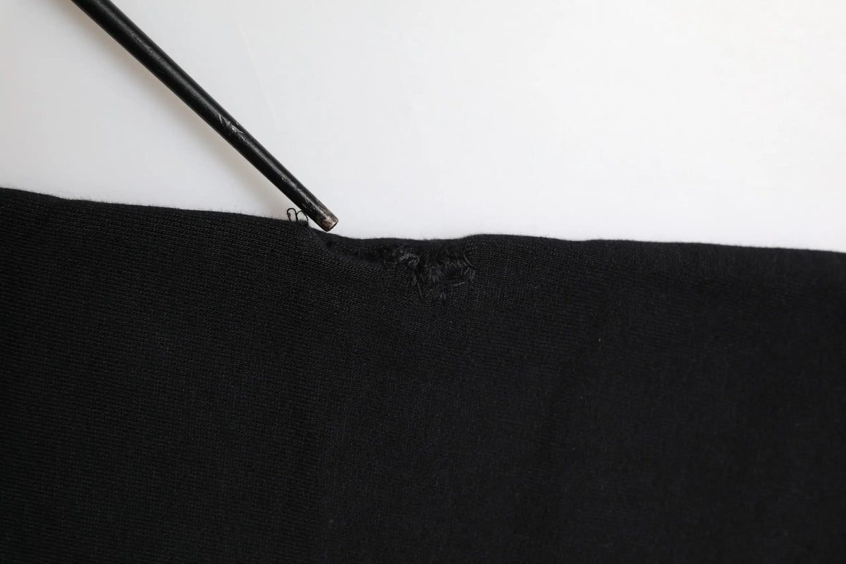 Dolce & gabbana black cotton crown jogger sweatpants with a small tear near the top edge pointed by a black pencil