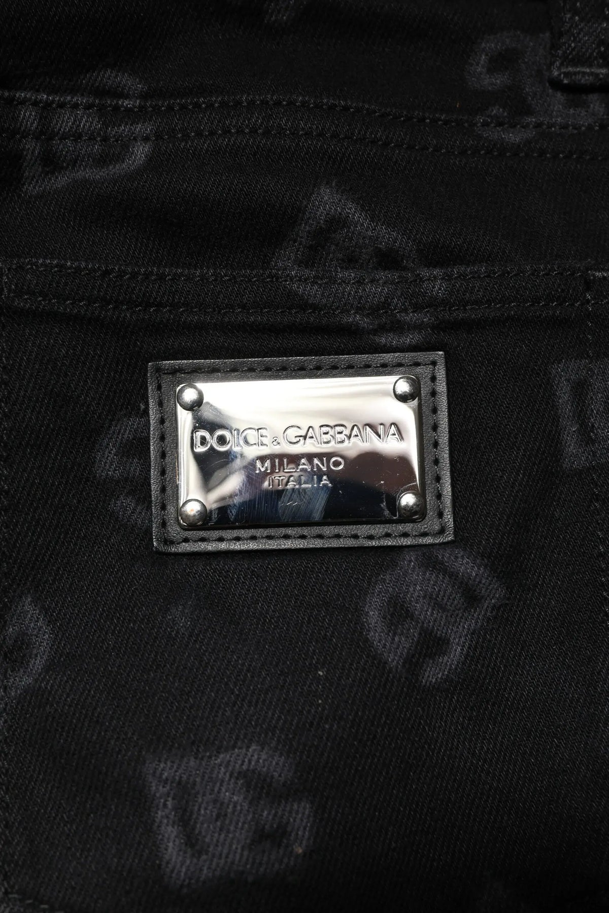 Jean slim en denim coton noir dolce gabbana avec plaque métallique argentée logo dolce gabbana milano italia