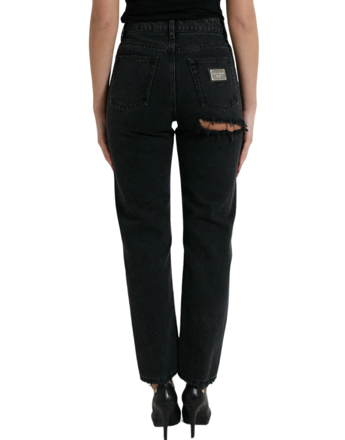 Vue arrière de jeans en denim noir dolce & gabbana en coton taille haute avec ourlet déchiré et patch argenté