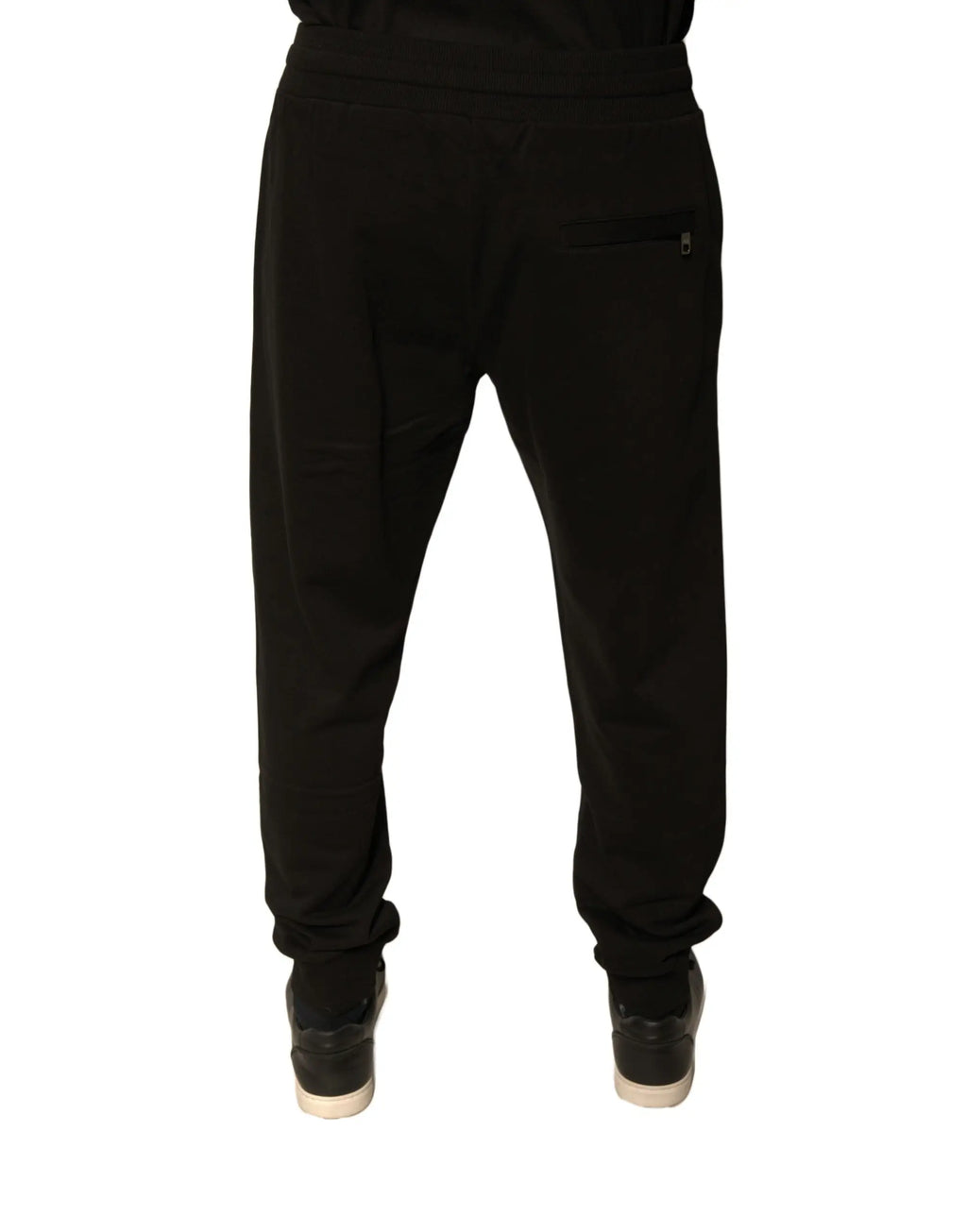 Dolce & Gabbana black cotton jogger sweatpants for men shown from the back with elastic cuffs and zippered pocket