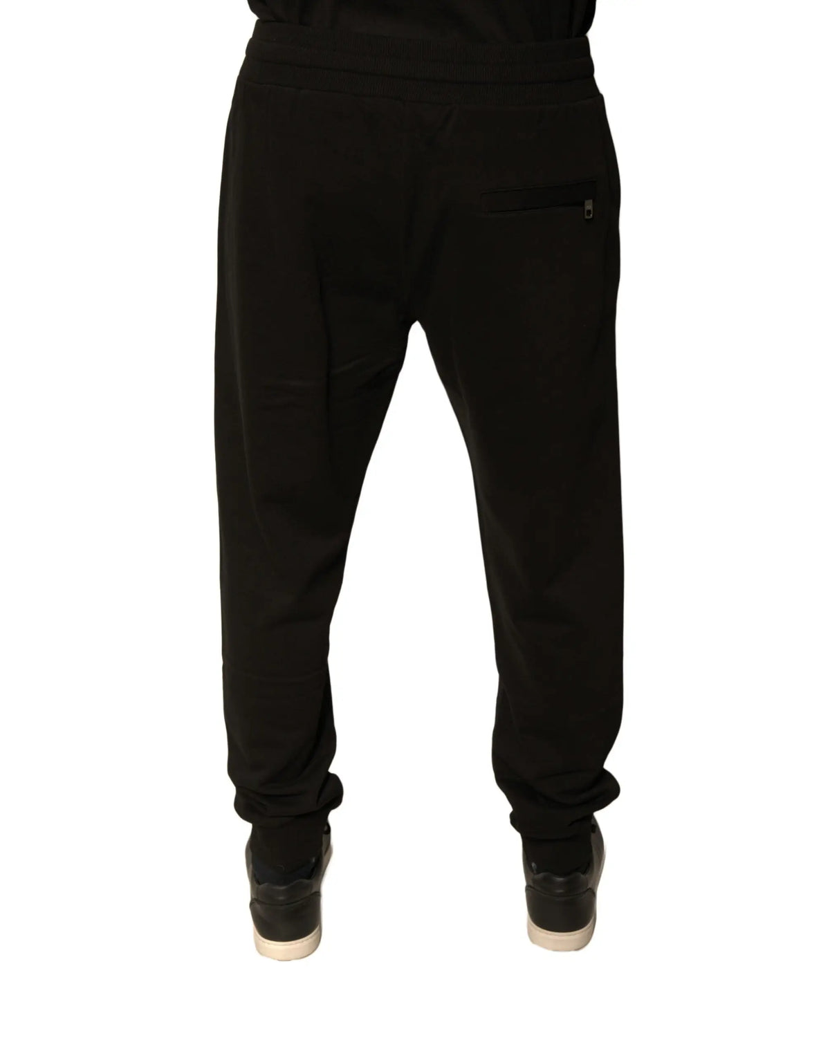 Dolce & Gabbana black cotton jogger sweatpants for men shown from the back with elastic cuffs and zippered pocket