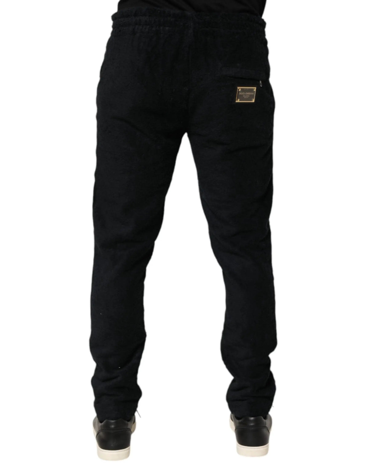 Vue arrière des joggers dolce & gabbana en coton noir avec écusson de marque rectangulaire doré sur la poche arrière