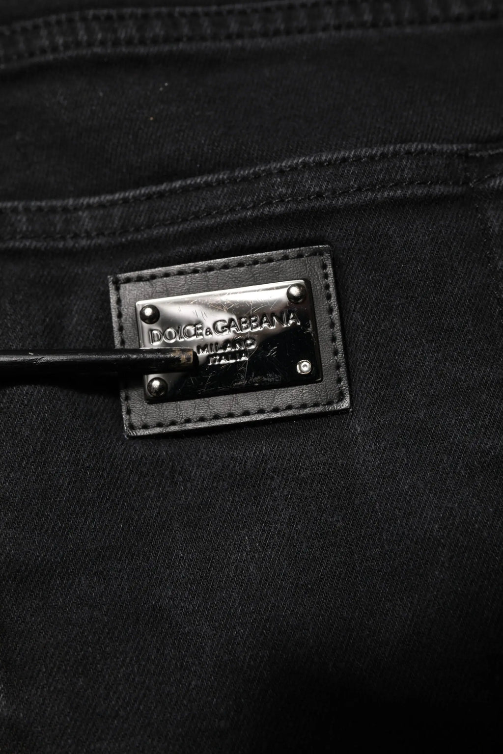 Patch en cuir noir avec plaque métal argent dolce & gabbana milano sur jean slim en denim coton noir