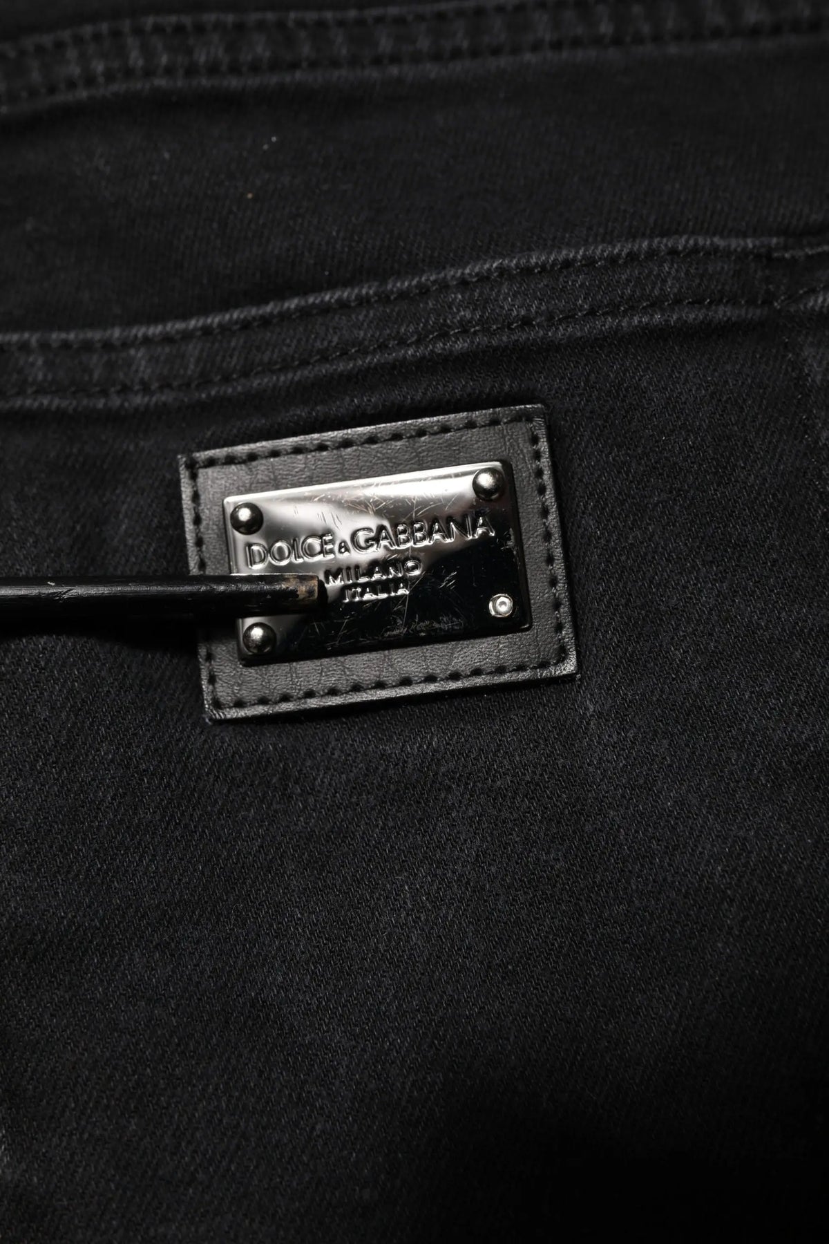 Patch en cuir noir avec plaque métal argent dolce & gabbana milano sur jean slim en denim coton noir