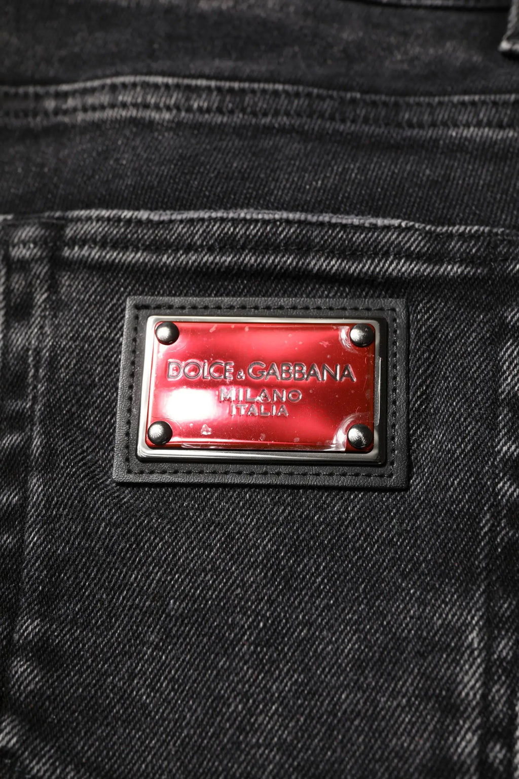 Plaque métallique rouge gravée dolce & gabbana milano italia sur bordure en cuir noir de jean denim noir skinny en coton homme