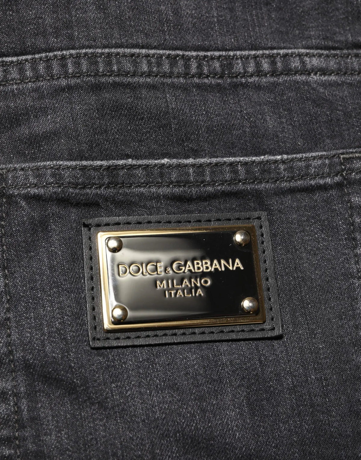 Jean slim fit noir en coton dolce gabbana avec déchirures et plaque métal dorée dolce gabbana milano italia