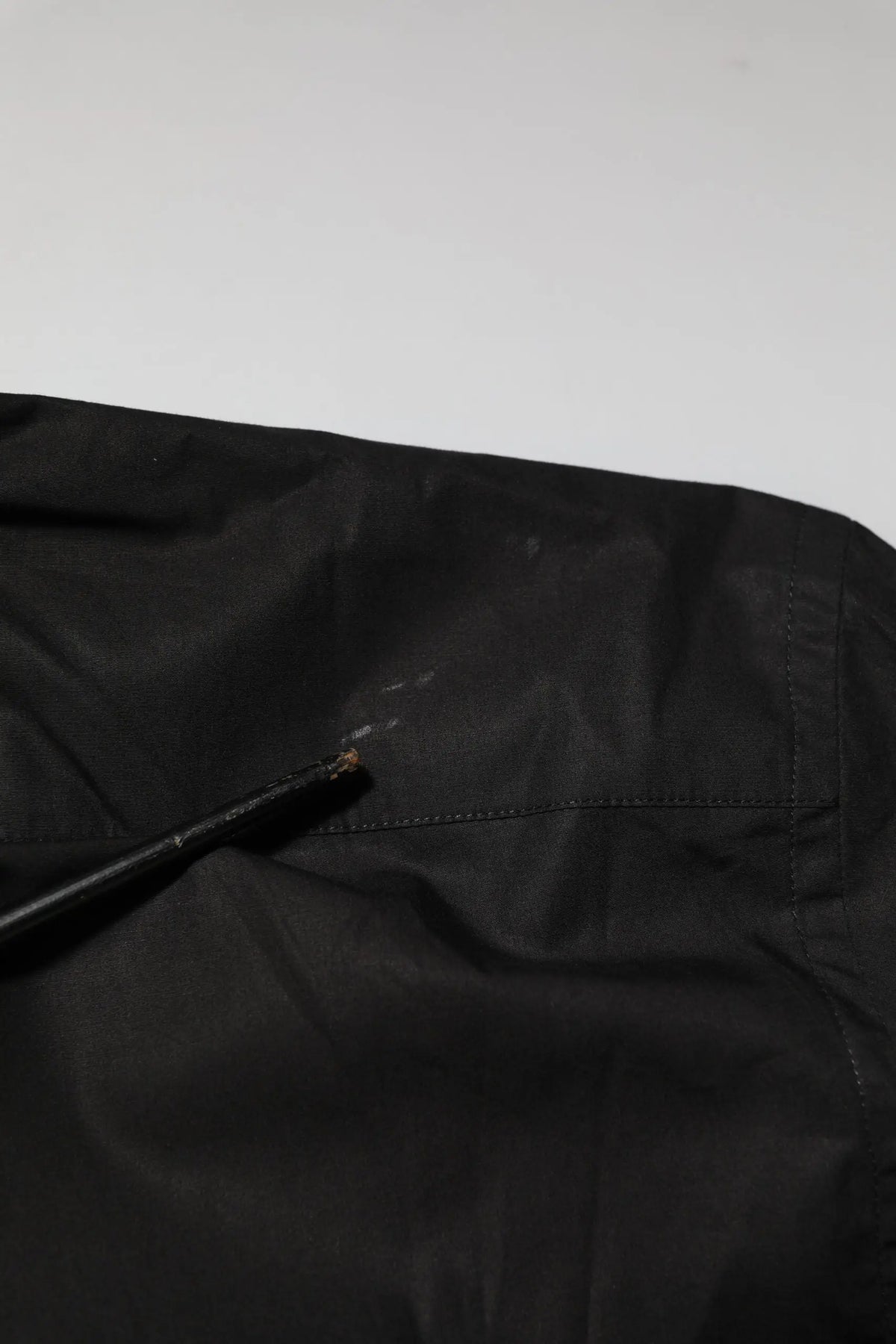Veste noire en nylon avec une petite déchirure près de la couture dans la chemise formelle noire en coton dolce & gabbana star sequin