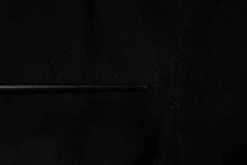 Un tige métallique noire lisse et légèrement réfléchissante associée au jean skinny en coton stretch noir dolce & gabbana homme