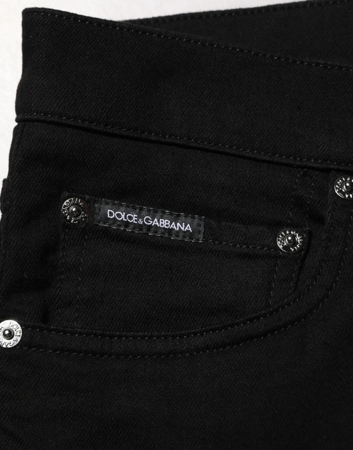 Jean slim noir en coton extensible pour homme dolce & gabbana avec boutons argentés et étiquette de marque sur la ceinture