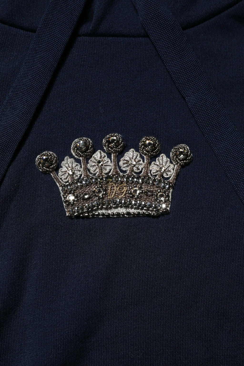 Broche couronne argentée scintillante avec perles noires et centre brodé or sur sweat à capuche coton noir dolce gabbana