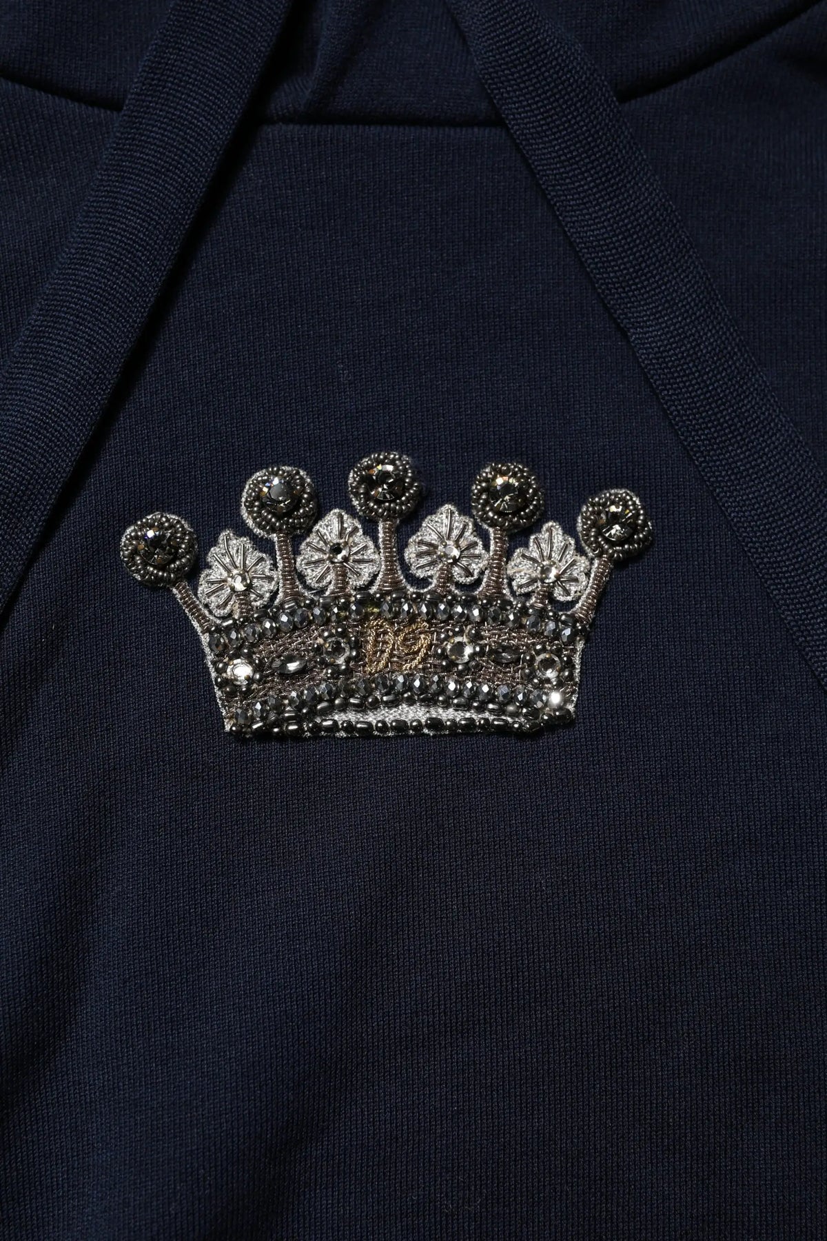 Broche couronne argentée scintillante avec perles noires et centre brodé or sur sweat à capuche coton noir dolce gabbana
