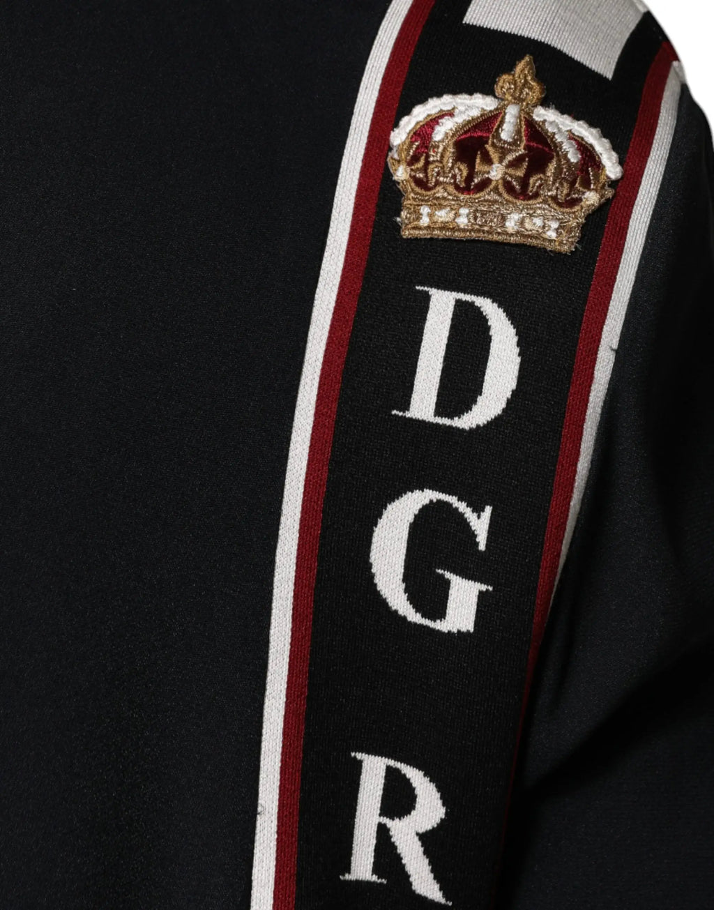 Manche de pull dolce & gabbana noir en maille avec rayure verticale blanche et rouge et broderie dgr sous couronne or