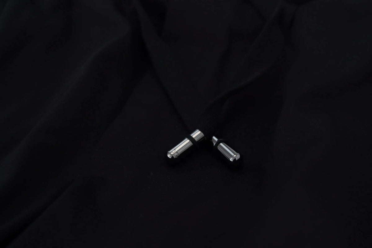Deux tirettes en métal argenté avec bandes en caoutchouc noir sur pantalon jogger homme dolce & gabbana noir imprimé dg