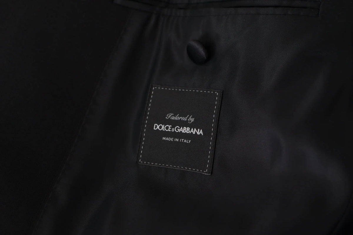 Étiquette en tissu noir avec bord blanc et texte cousu tailored by dolce & gabbana made in italy sur manteau noir doublé croisé