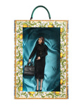 Poupée dolce & gabbana en robe noire en dentelle dans un cadre lumineux à motifs citron avec doublure satinée verte