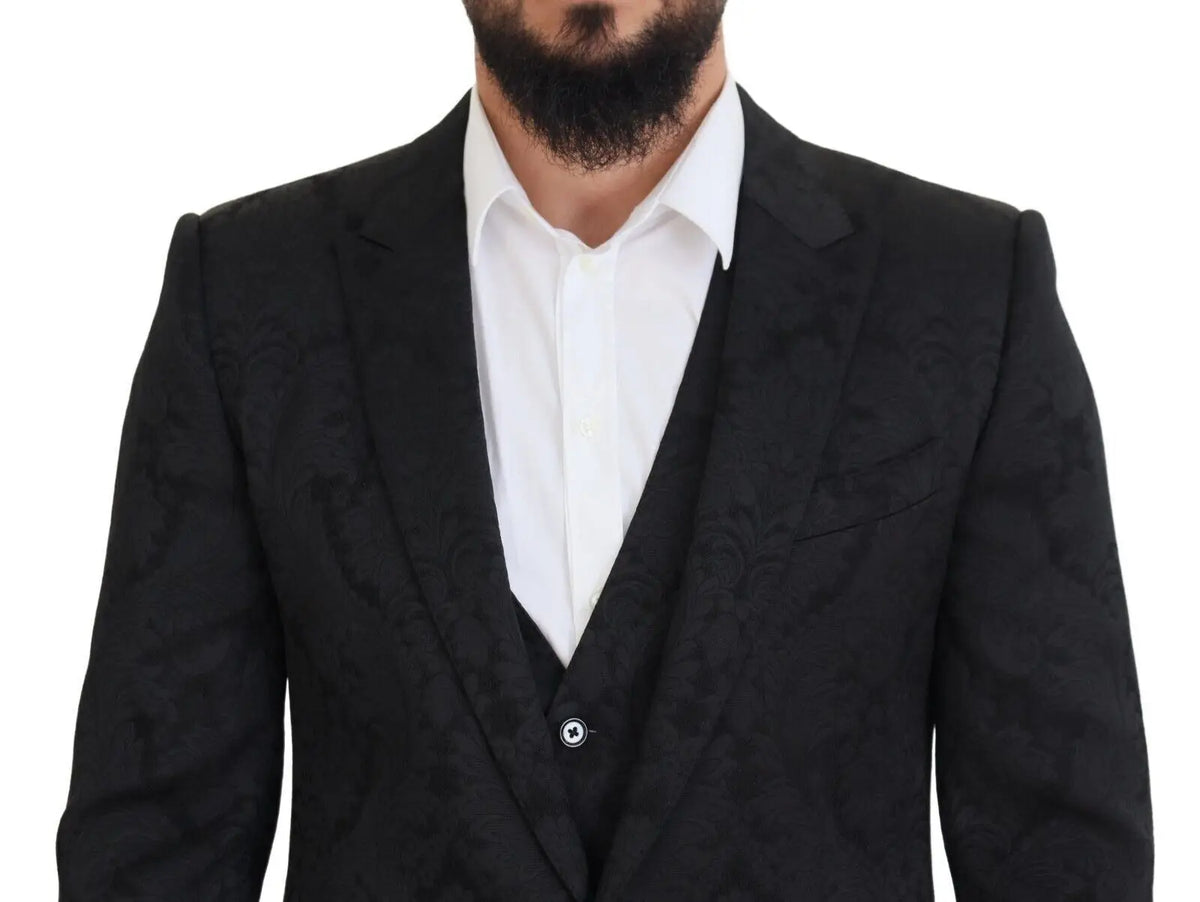 Veste de costume noir texturée avec motif floral subtile dolce gabbana portée sur chemise blanche et gilet assorti