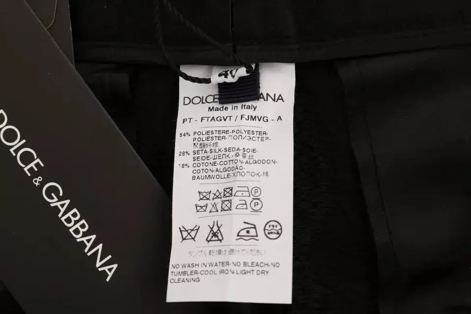 Étiquette de soin noire dolce & gabbana au dos avec composition multilingue et instructions pour pantalon brocart floral noir taille haute