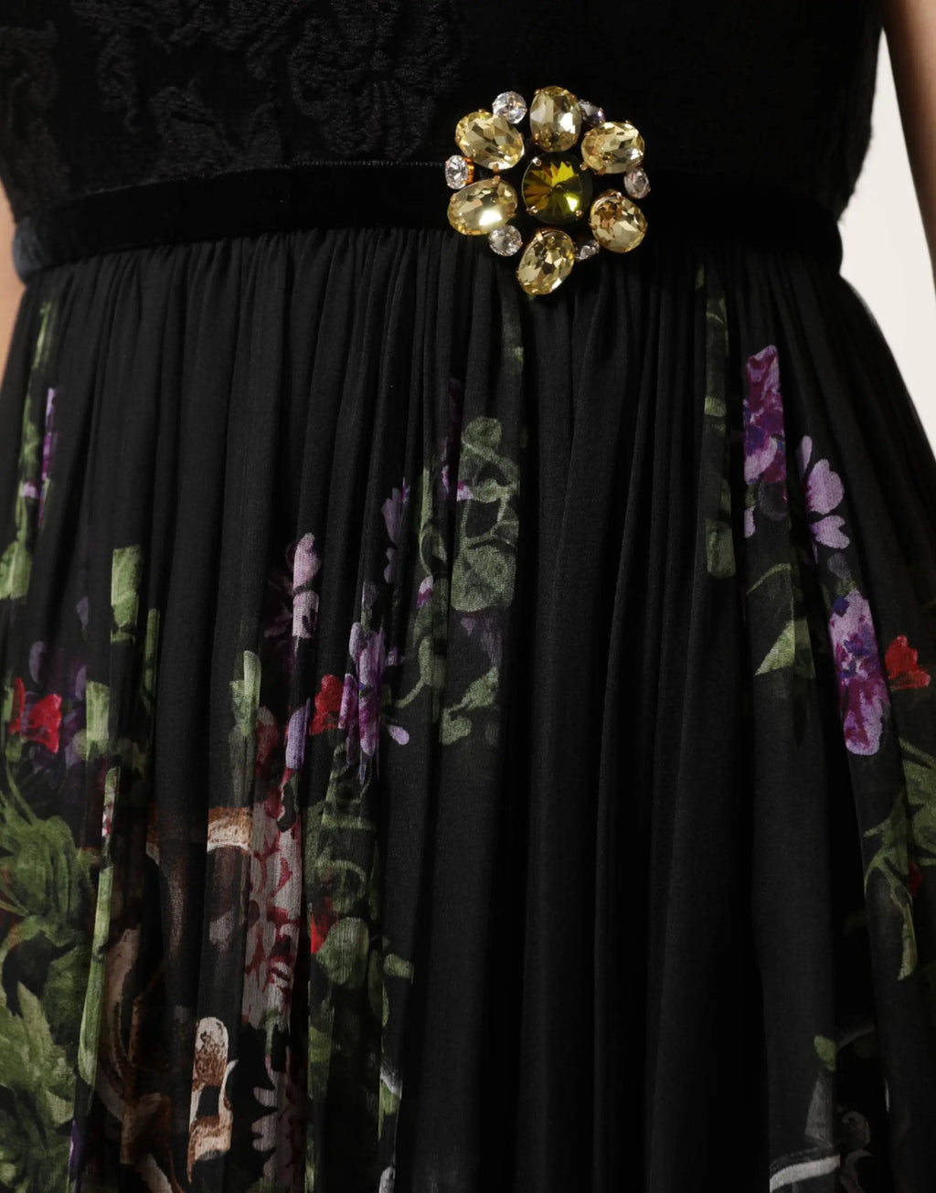 Broche fleur en cristal clair et or brillant sur ceinture en velours noir de la robe dolce gabbana noire à motif floral