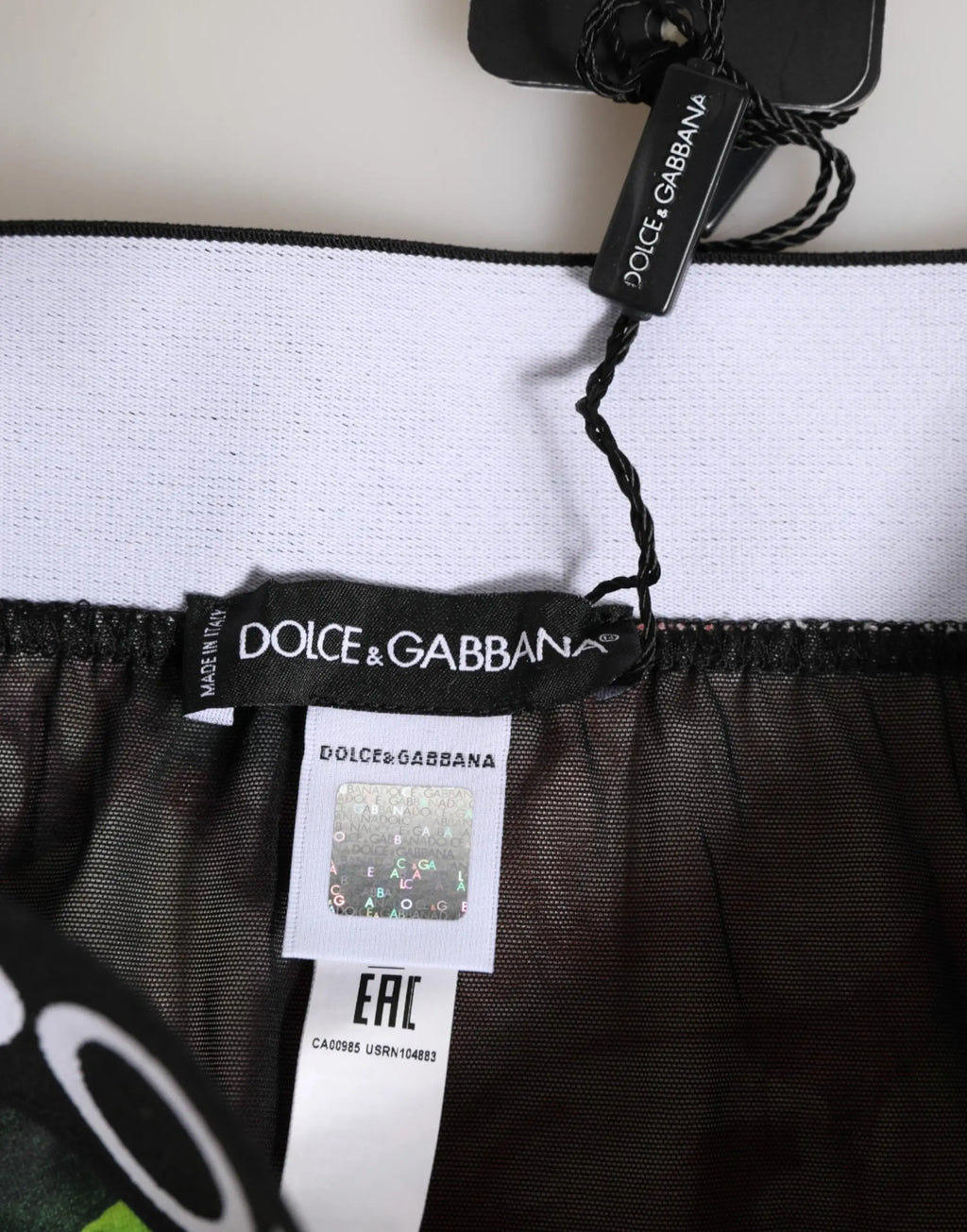 Jupe en maille noire transparente avec ceinture élastique blanche et étiquettes dolce & gabbana sur dessous imprimé floral haute taille