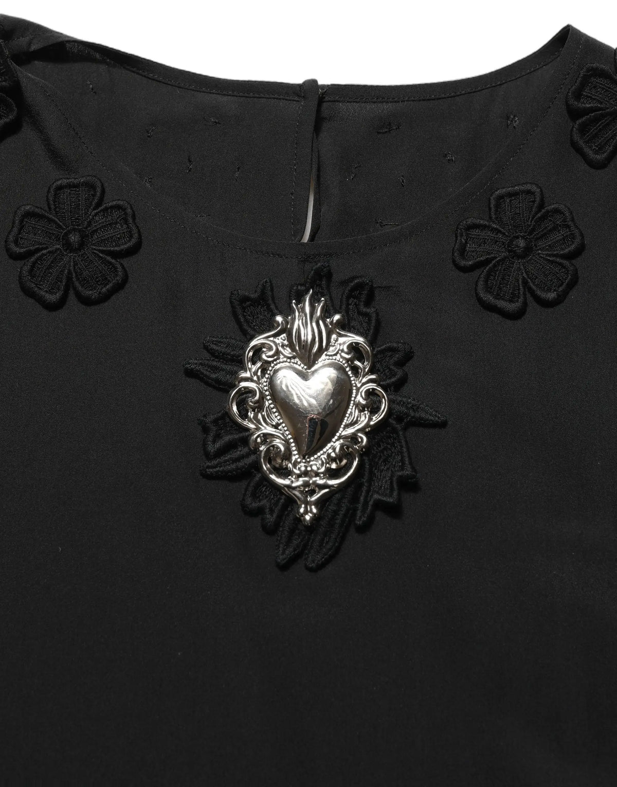 Broche cœur argent ornée de filigrane sur blouse noire en soie avec appliqué floral dolce gabbana