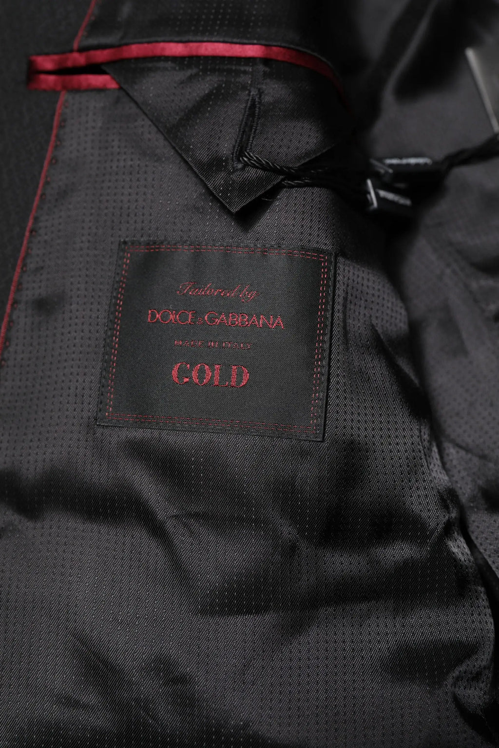 Étiquette noire dolce & gabbana cold avec couture et texte rouge sur blazer costume simple boutonnage gold noir