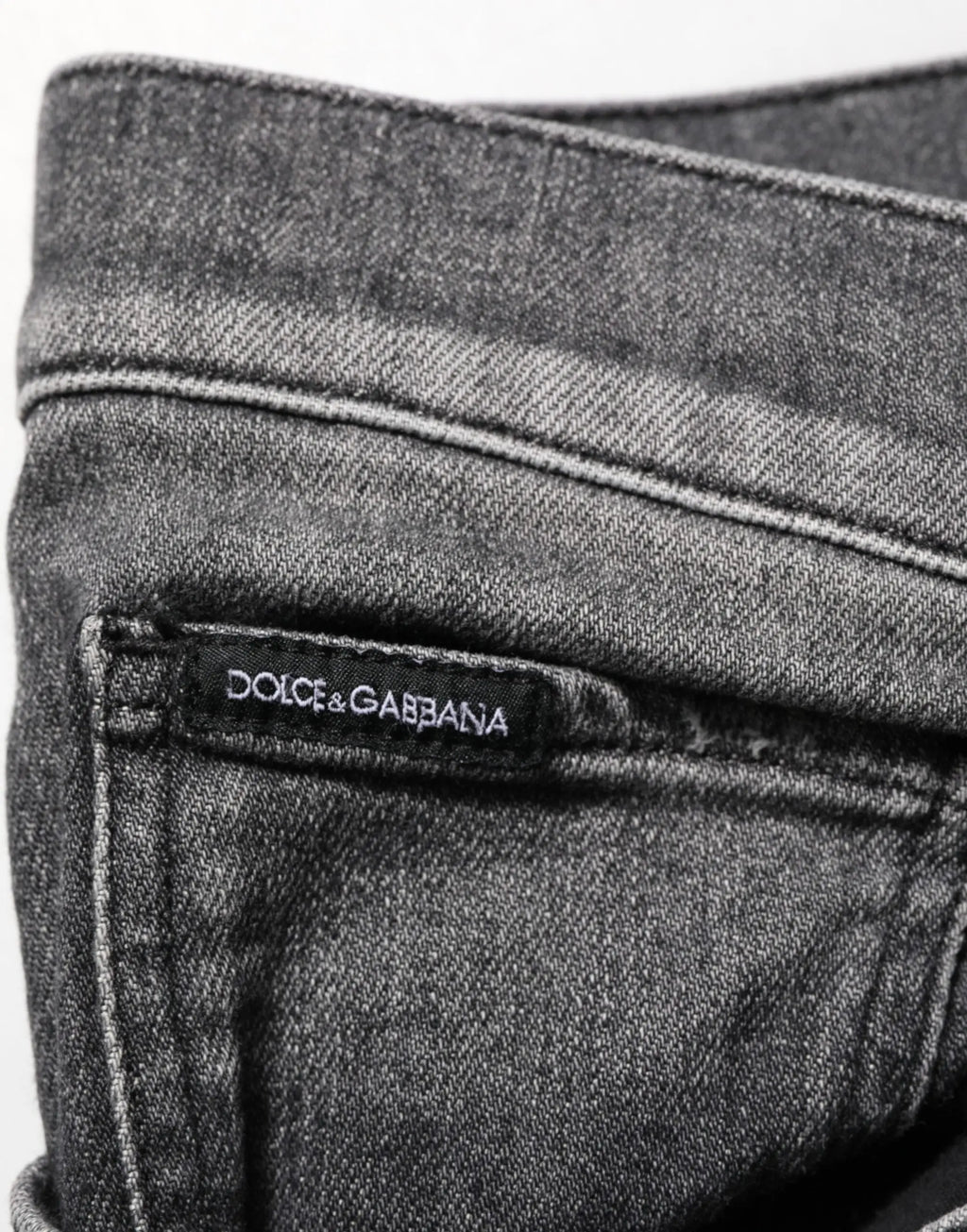 Jean slim droit en denim gris foncé avec délavage subtil et étiquette dolce gabbana cousue à la taille