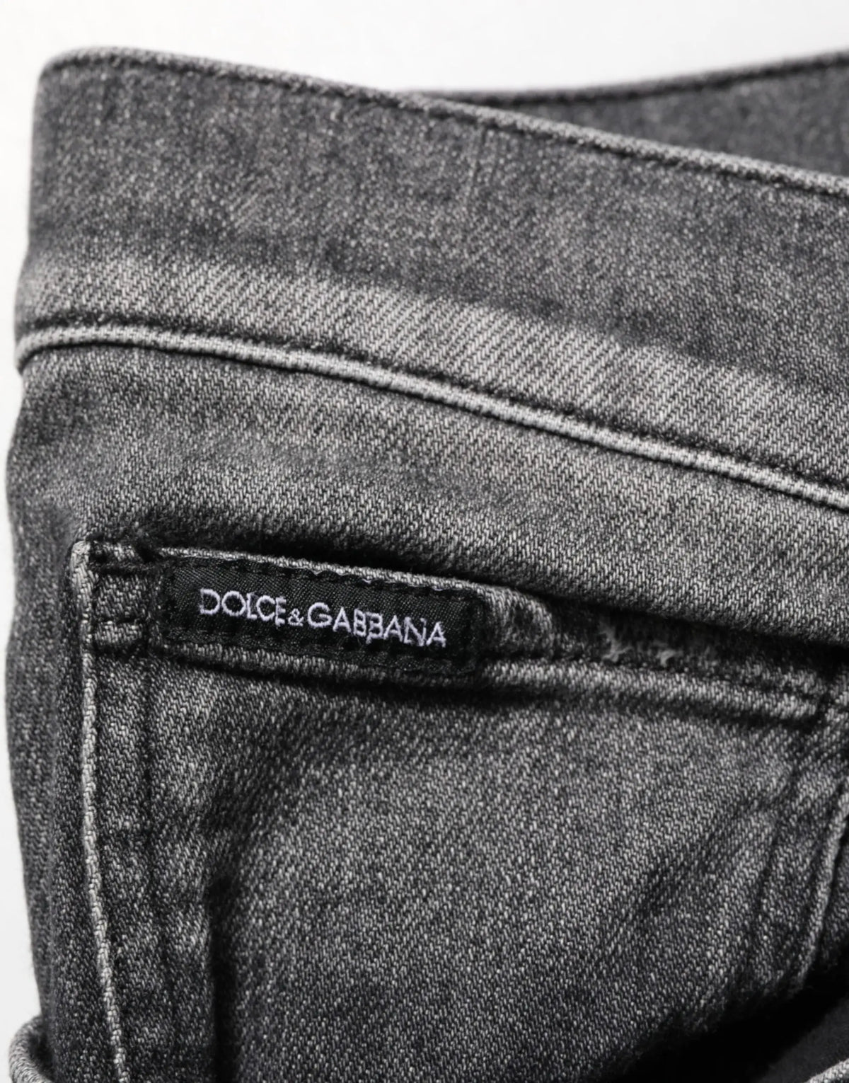 Jean slim droit en denim gris foncé avec délavage subtil et étiquette dolce gabbana cousue à la taille