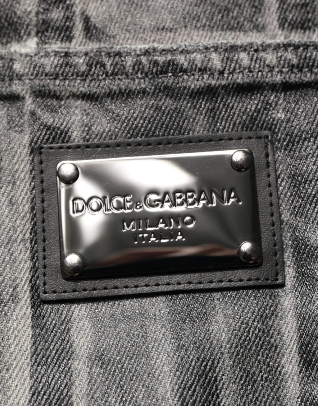 Plaque argentée métallique embossée dolce & gabbana milano italia cousue sur jean denim gris foncé noir à imprimé graphique