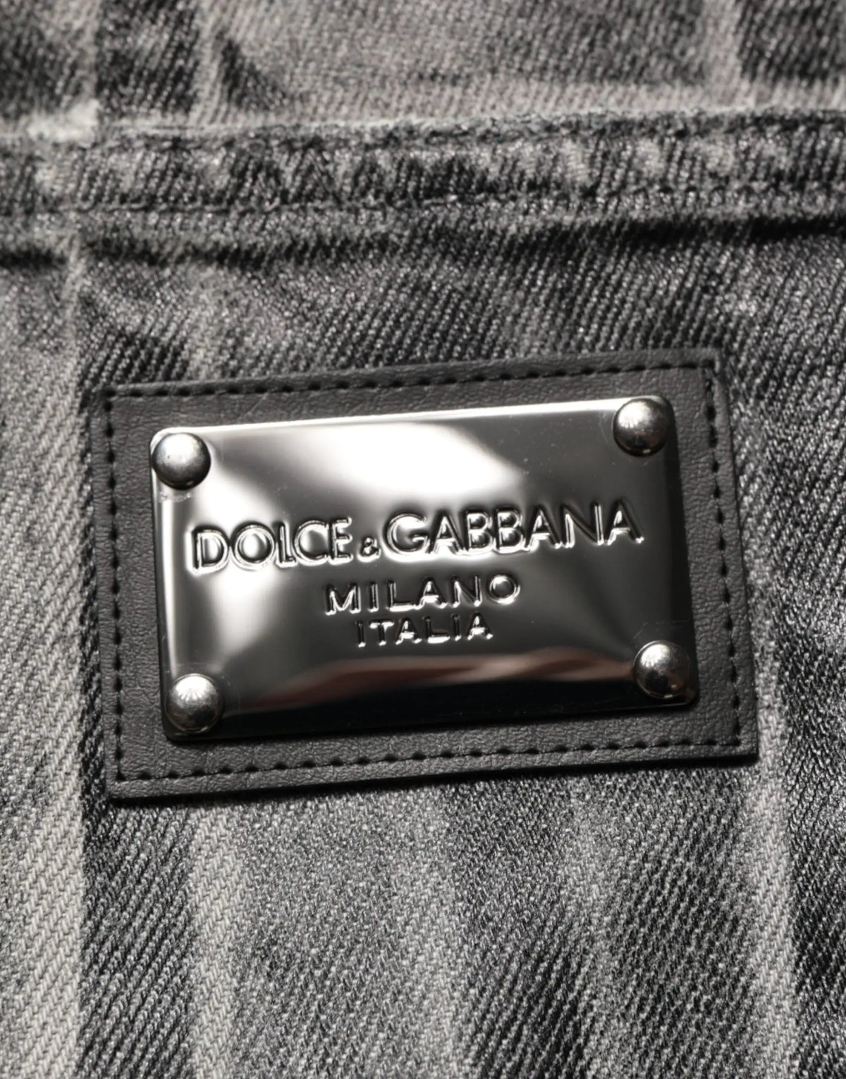 Plaque argentée métallique embossée dolce & gabbana milano italia cousue sur jean denim gris foncé noir à imprimé graphique