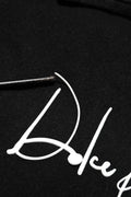 Logo dolce blanc en cursive brodé sur tissu noir du sweat à capuche noir dolce gabbana avec impression logo
