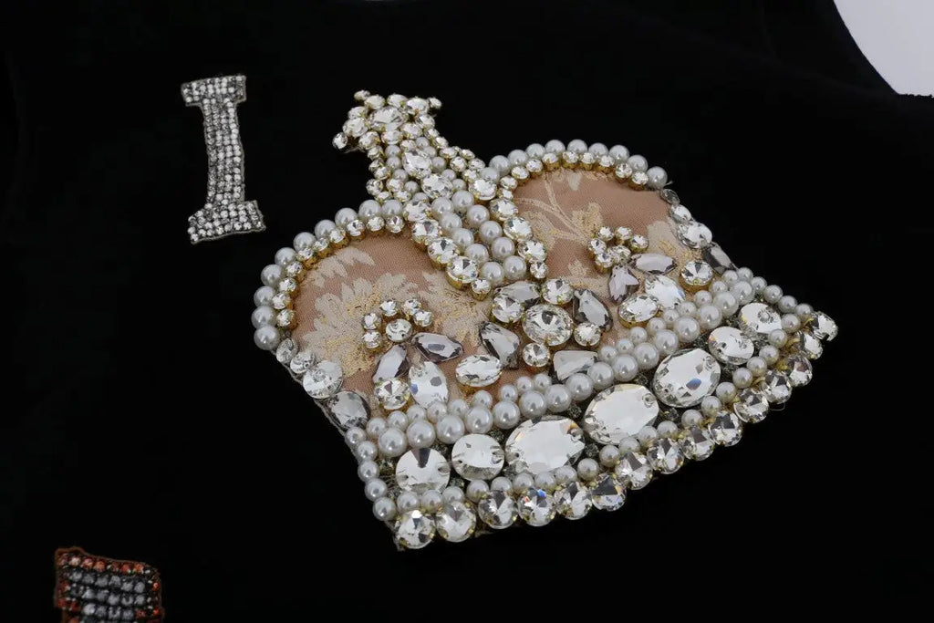 Une broche en forme de couronne noire dolce gabbana ornée de strass clairs et de perles blanches pour robe shift crystal