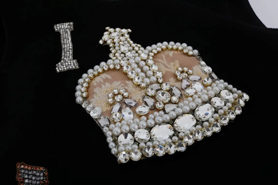 Une broche en forme de couronne noire dolce gabbana ornée de strass clairs et de perles blanches pour robe shift crystal