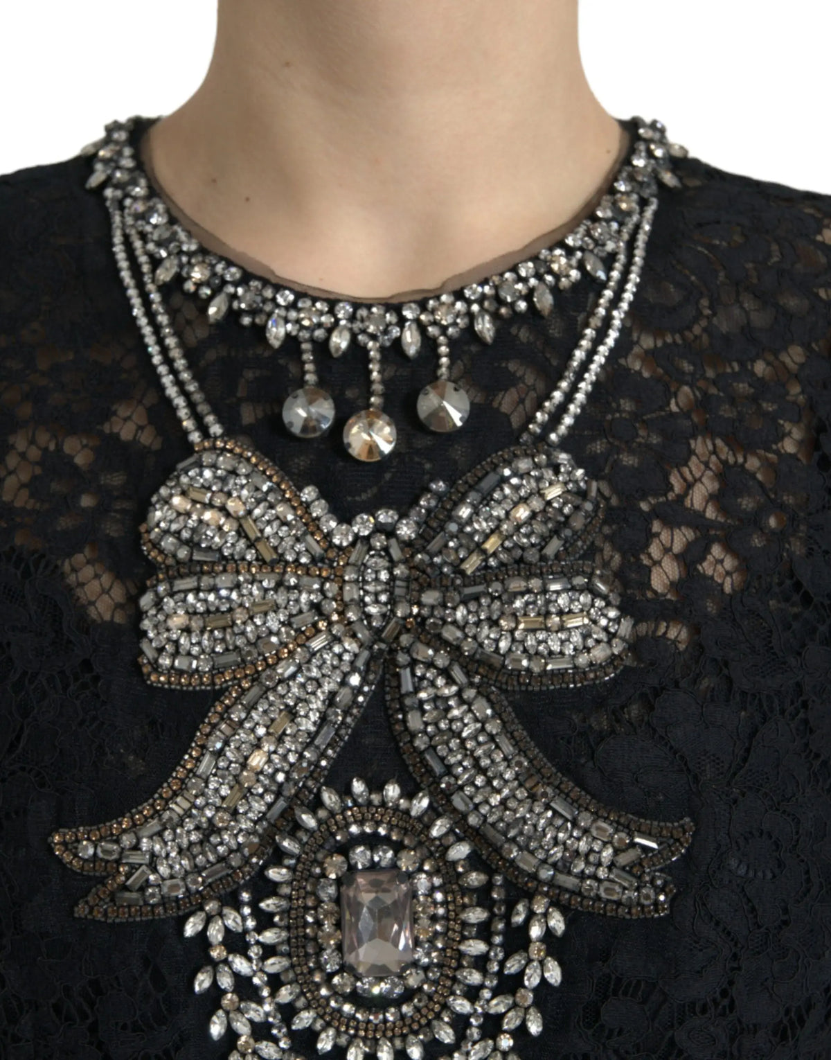 Une élégante robe fourreau dolce gabbana en dentelle noire ornée d’un nœud à perles argentées et noires