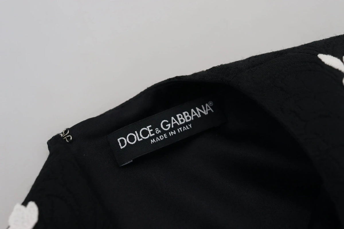 Étiquette noire dolce gabbana avec texte blanc made in italy sur robe noire à manches courtes en dentelle style trapèze