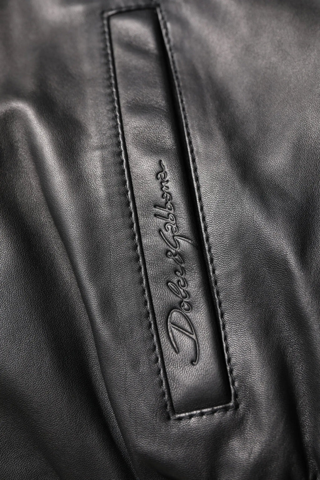 Patch en cuir noir avec logo embossé dolce & gabbana sur une veste biker zippée en agneau noir