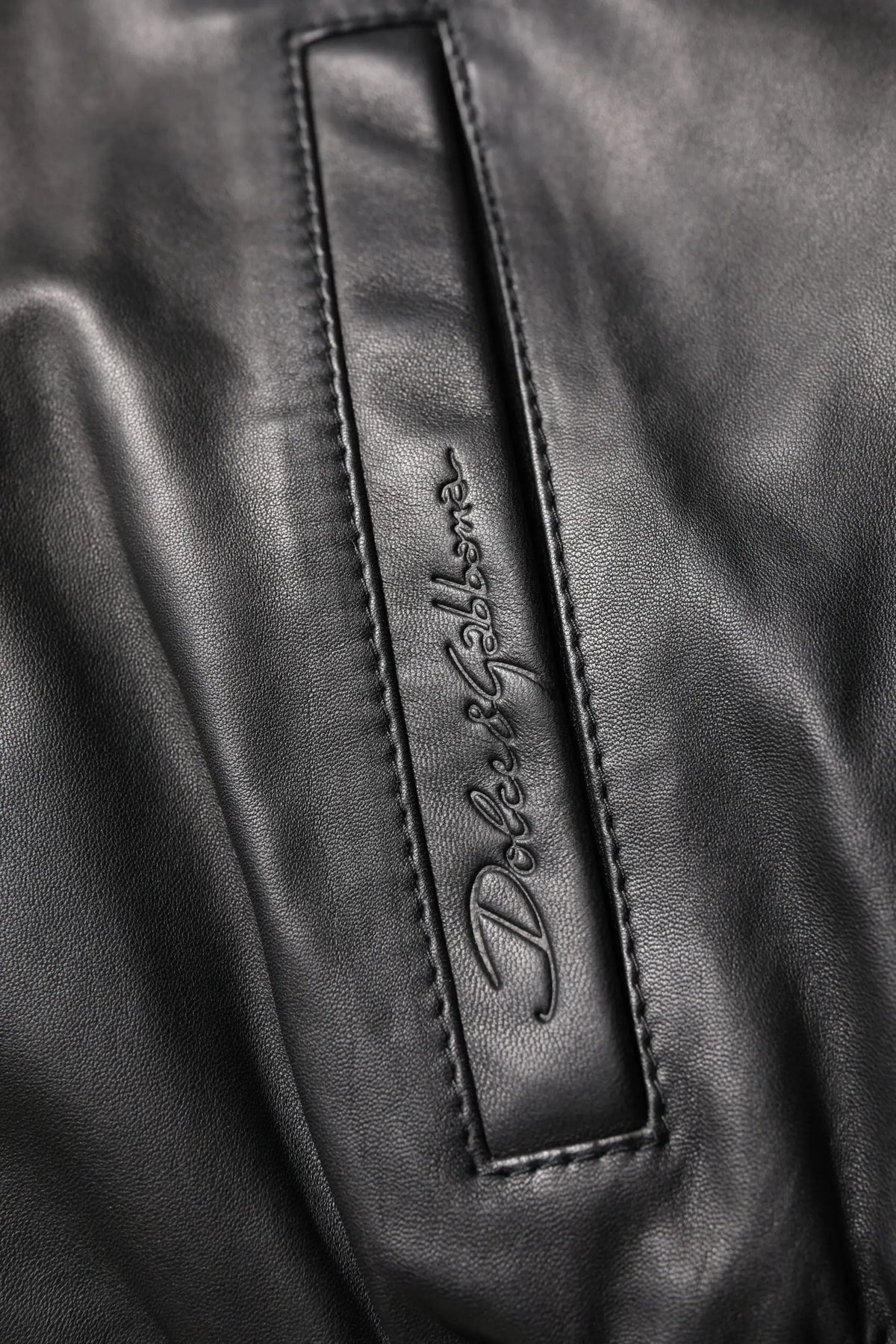 Patch en cuir noir avec logo embossé dolce & gabbana sur une veste biker zippée en agneau noir