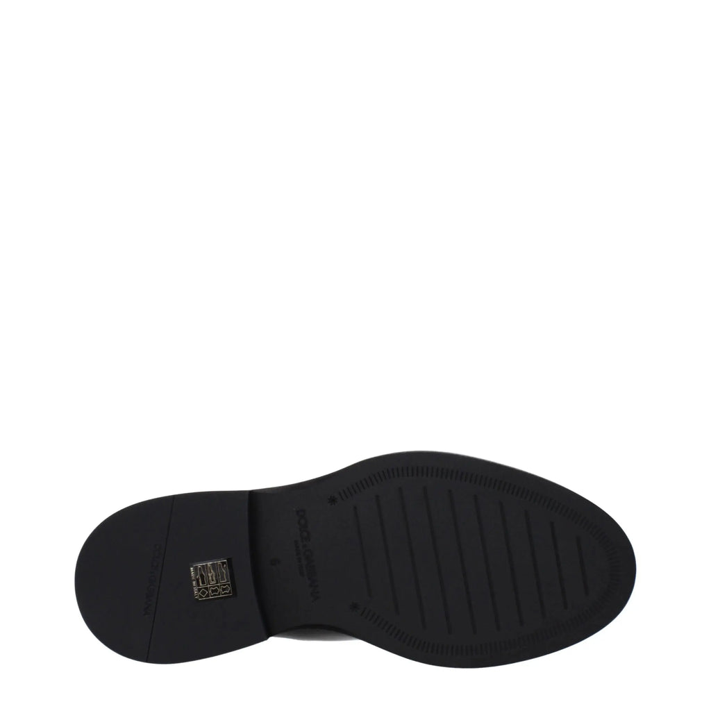 Semelle en caoutchouc noir texturée avec étiquette de marque rectangulaire au talon vue arrière des bottines en cuir noir dolce & gabbana