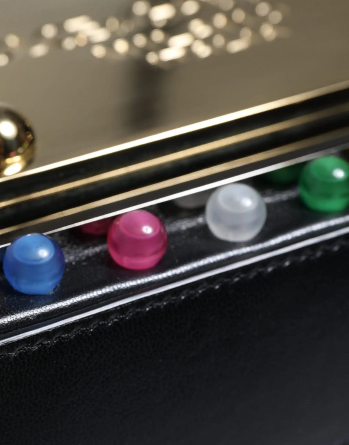 Un sac banane ceinture en cuir noir dolce & gabbana orné de perles de pierres précieuses translucides colorées