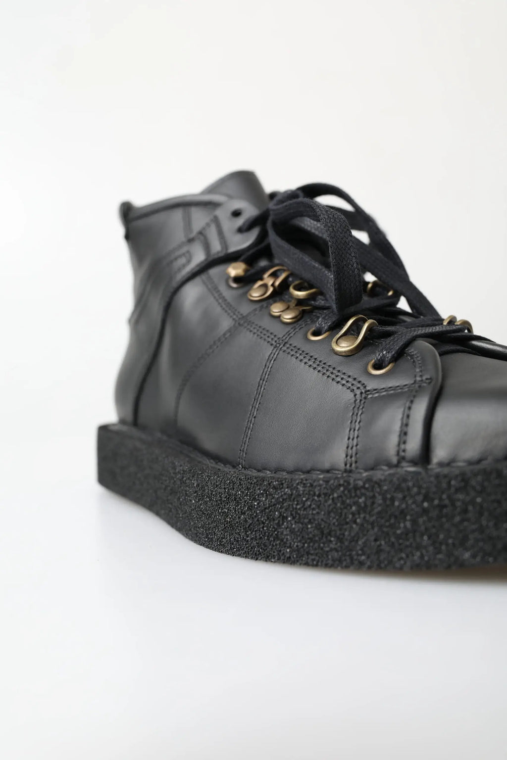 Bottes slip on stretch dolce & gabbana en cuir noir avec tige haute brillante, œillets dorés et semelle en caoutchouc texturée