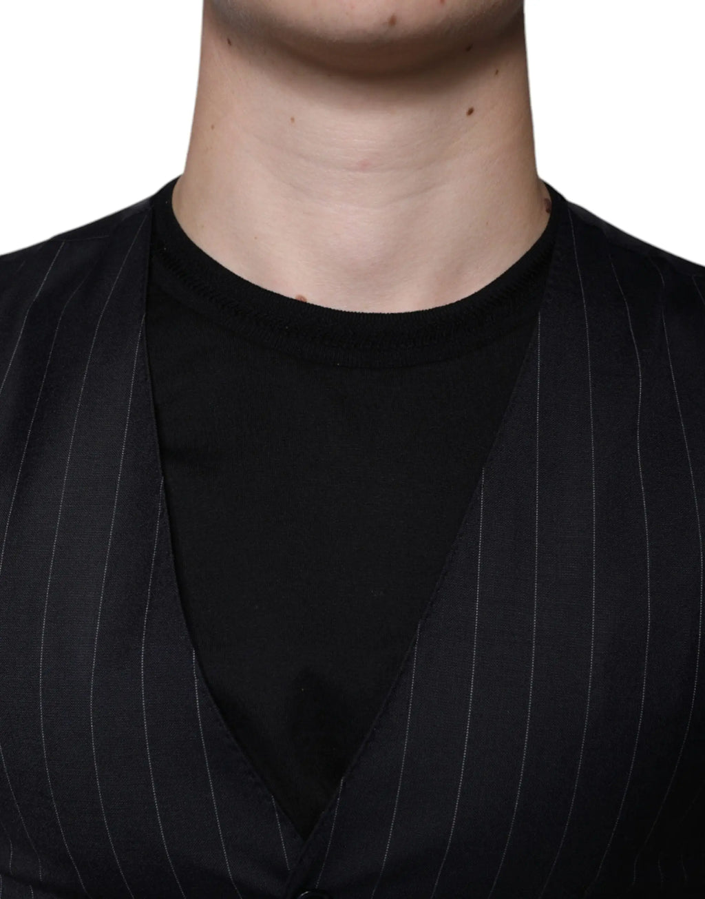 Dolce & gabbana veston en cuir noir sans manches porté sur un tee noir col rond avec fines rayures verticales