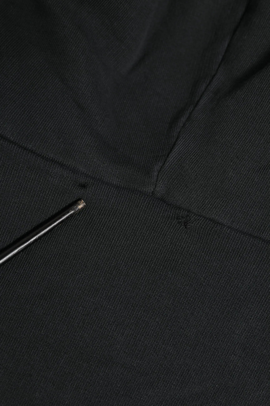 Tissu noir texturé avec une aiguille métallique reposant sur le sweat à capuche zippé dolce & gabbana logo noir
