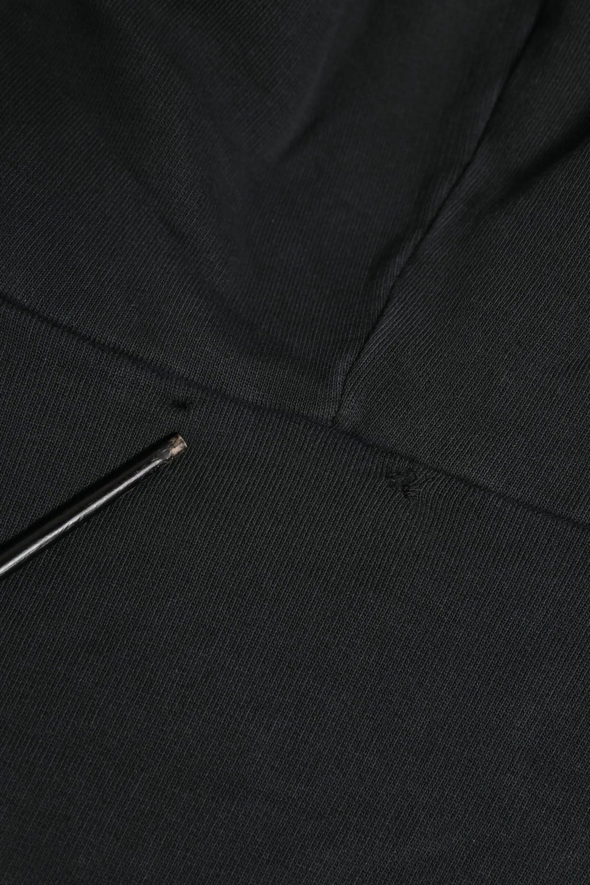 Tissu noir texturé avec une aiguille métallique reposant sur le sweat à capuche zippé dolce & gabbana logo noir