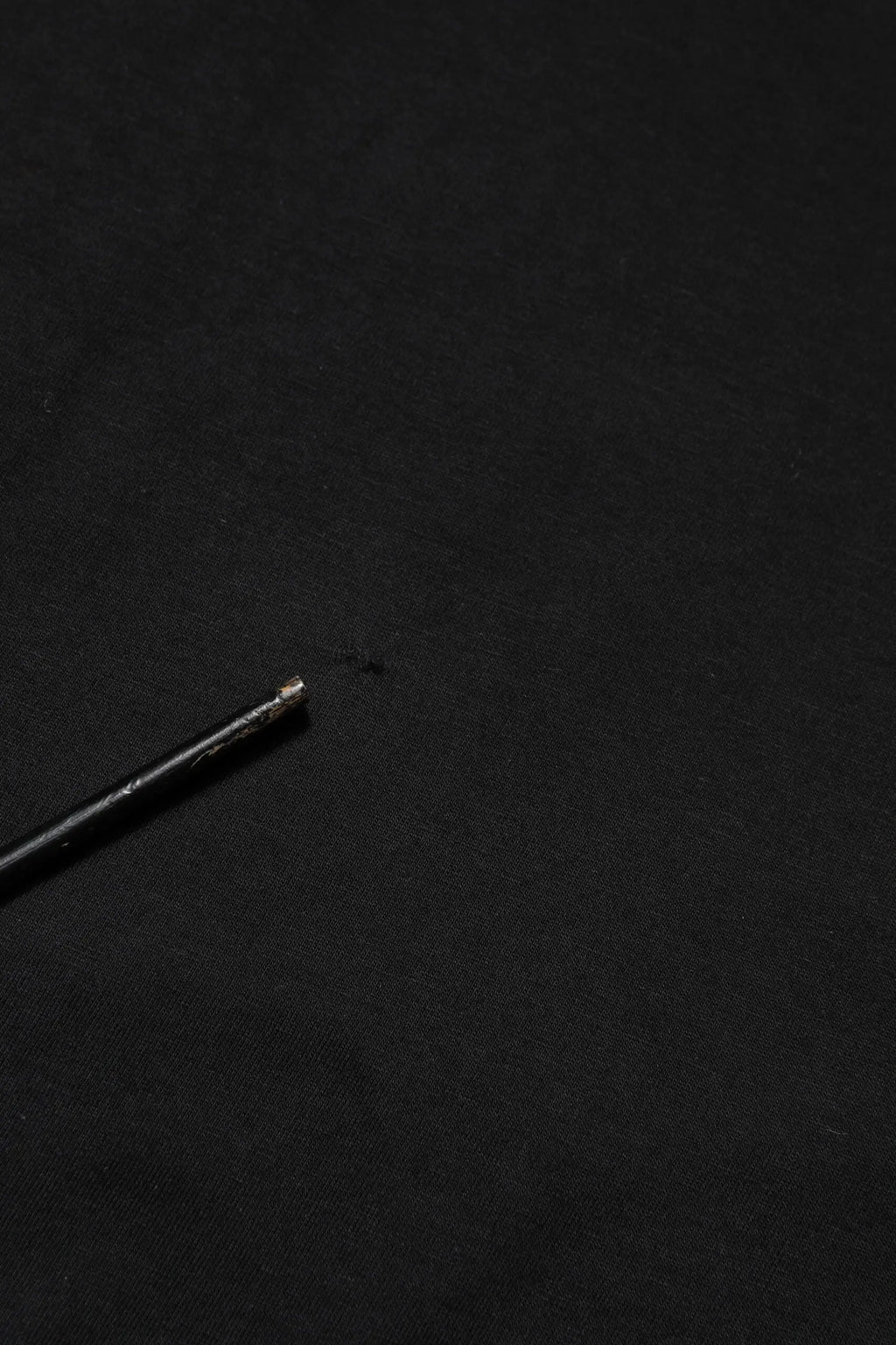 Stylo noir avec pointe métallique posé sur un t-shirt dolce & gabbana logo noir en coton col rond