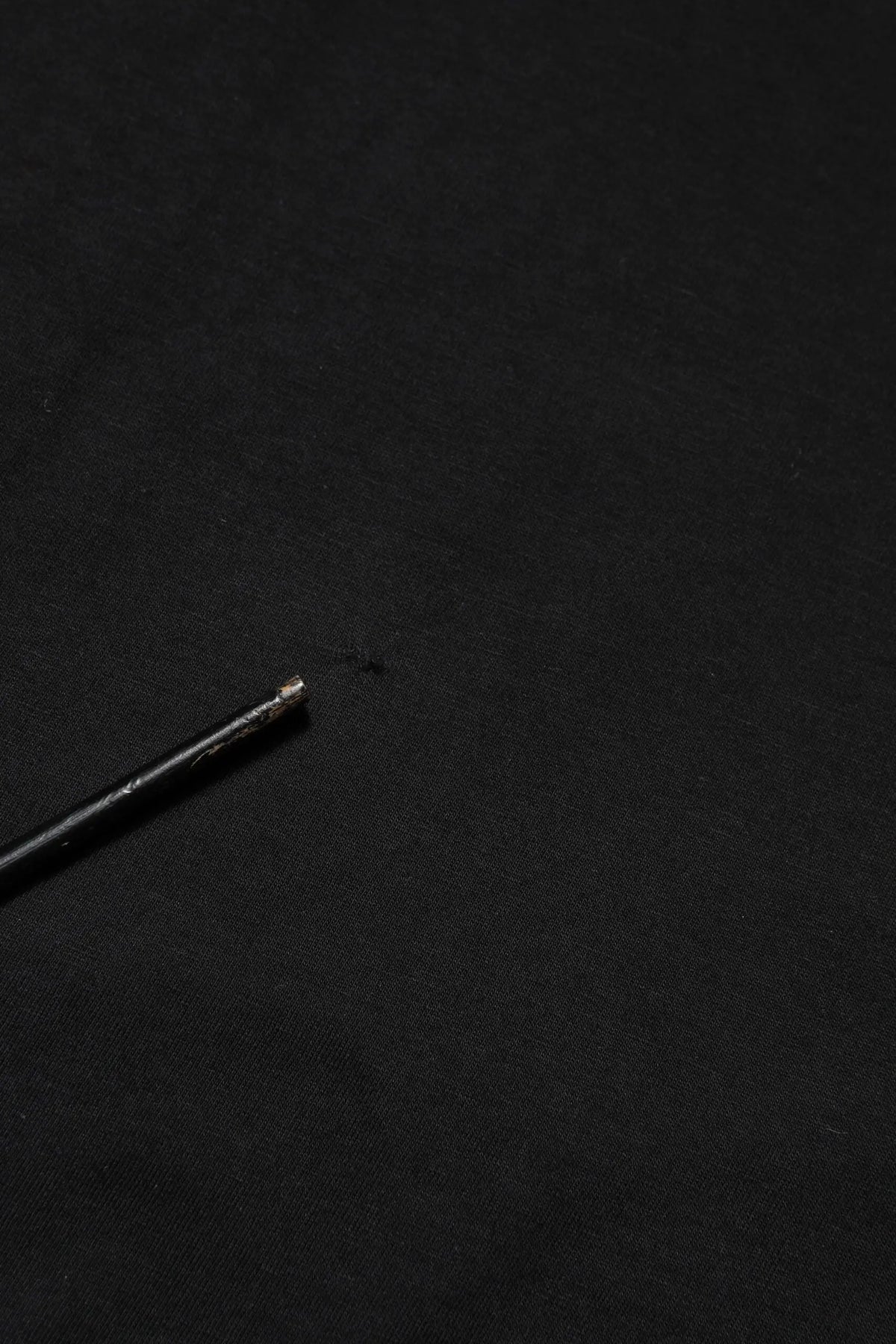 Stylo noir avec pointe métallique posé sur un t-shirt dolce & gabbana logo noir en coton col rond