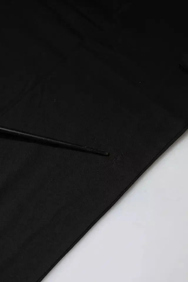 Portefeuille en cuir noir avec une lanière fine posée en diagonale sur un t-shirt coton à manches courtes dolce & gabbana noir imprimé logo